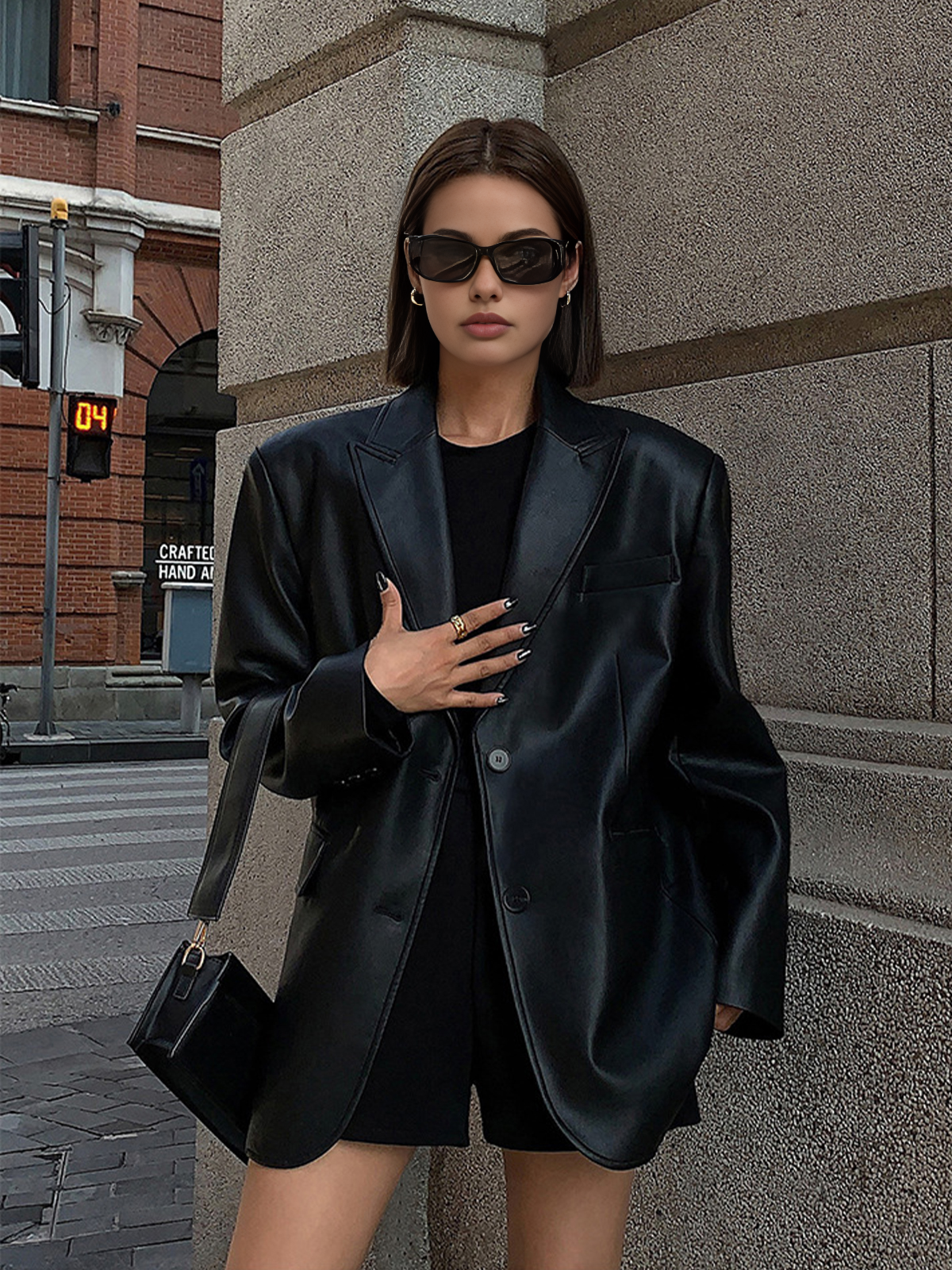 Black faux leather oversized blazer with single-button front and padded shoulders