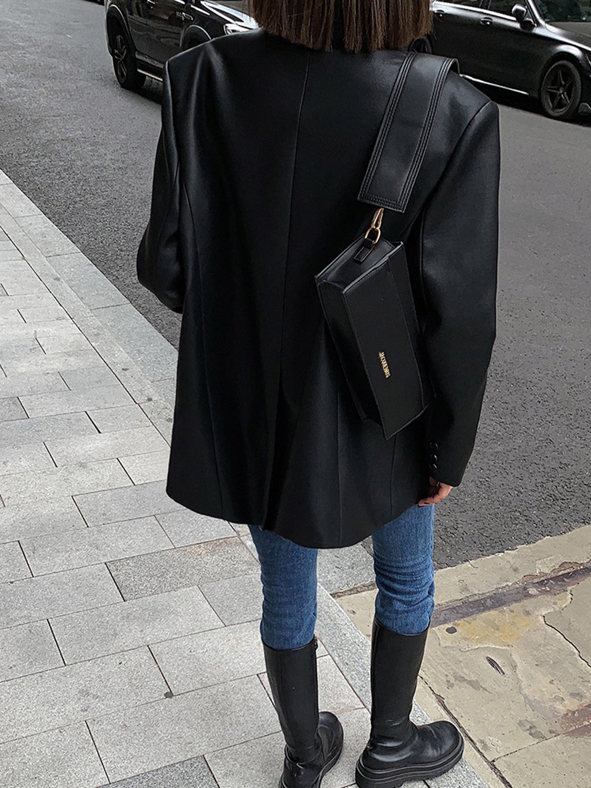 Black faux leather blazer back view with structured shoulders and long sleeves