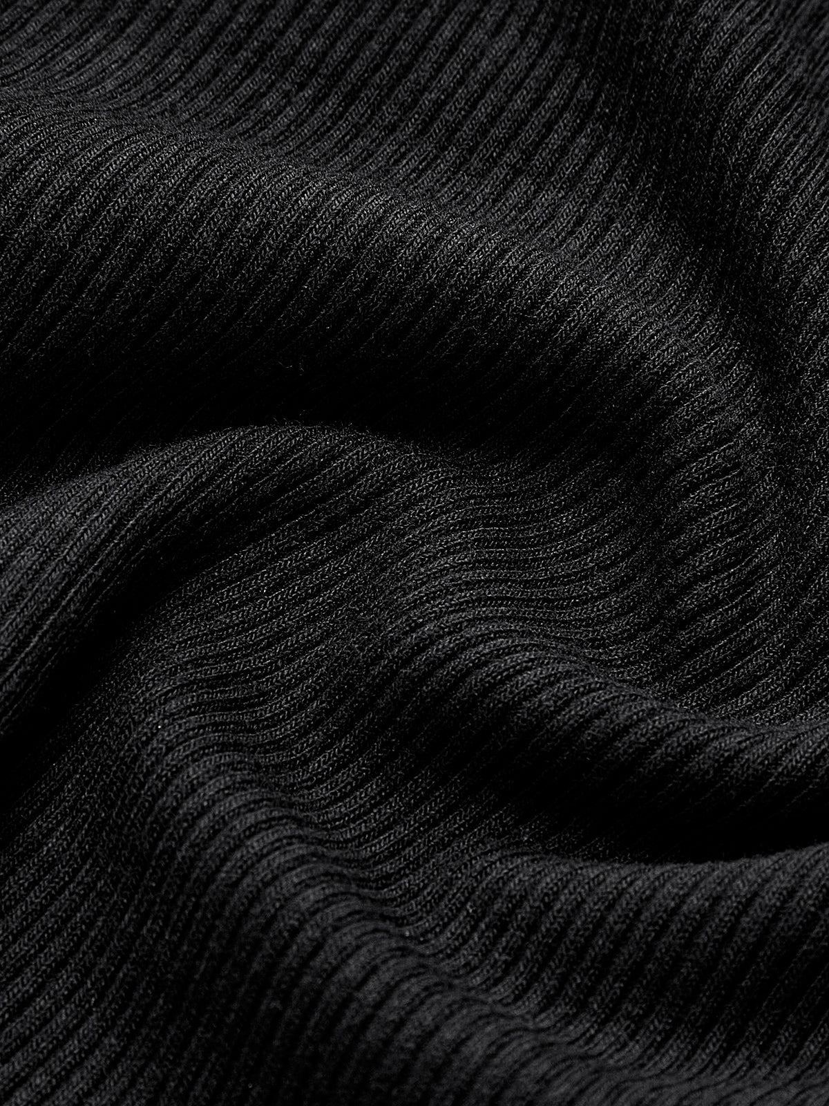 Close-up of black ribbed knit fabric texture, tightly ribbed with soft stretch lines