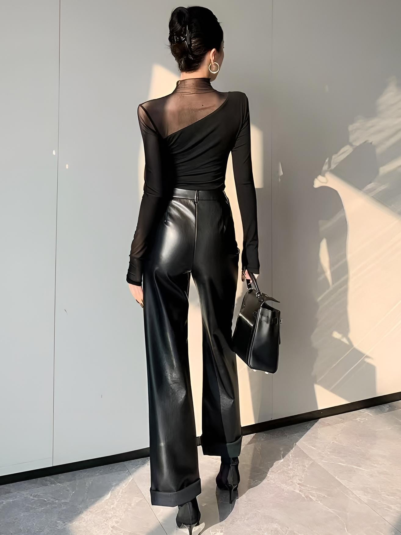 Back view of black mesh long-sleeve top with mock neck and curved seam detail