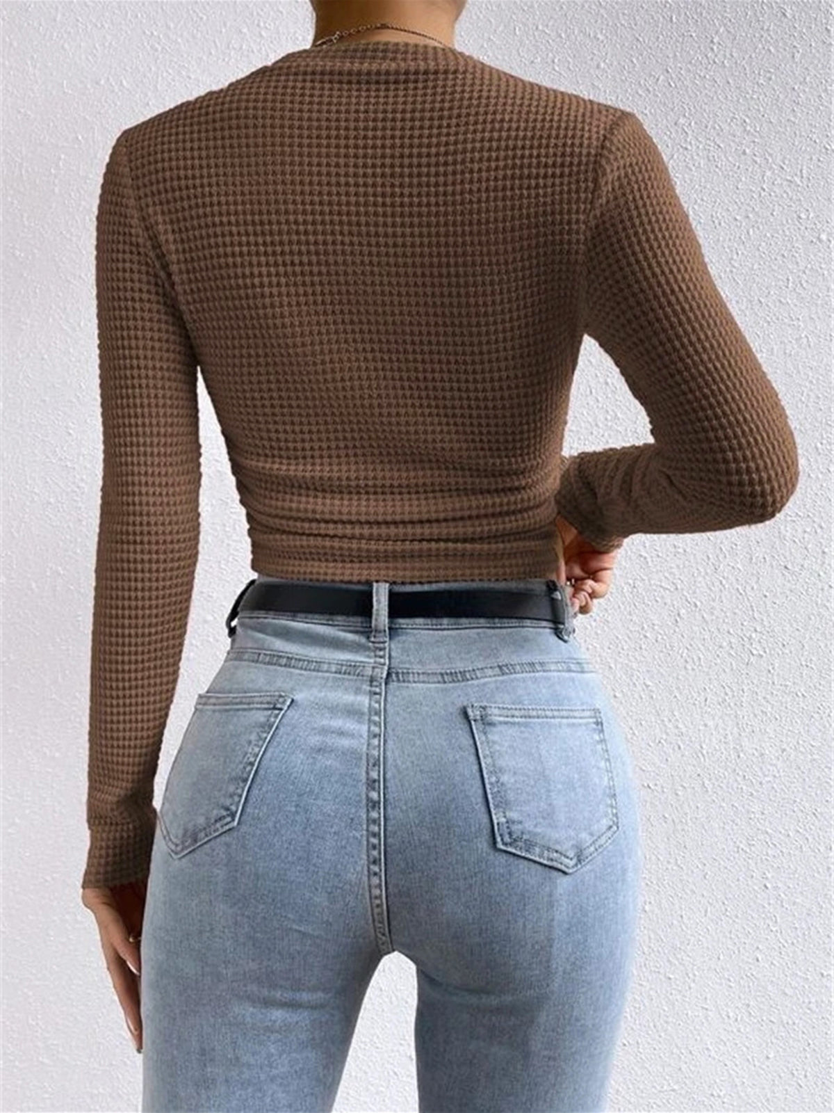 Back view: light brown waffle knit long-sleeve crop top with ruched hem