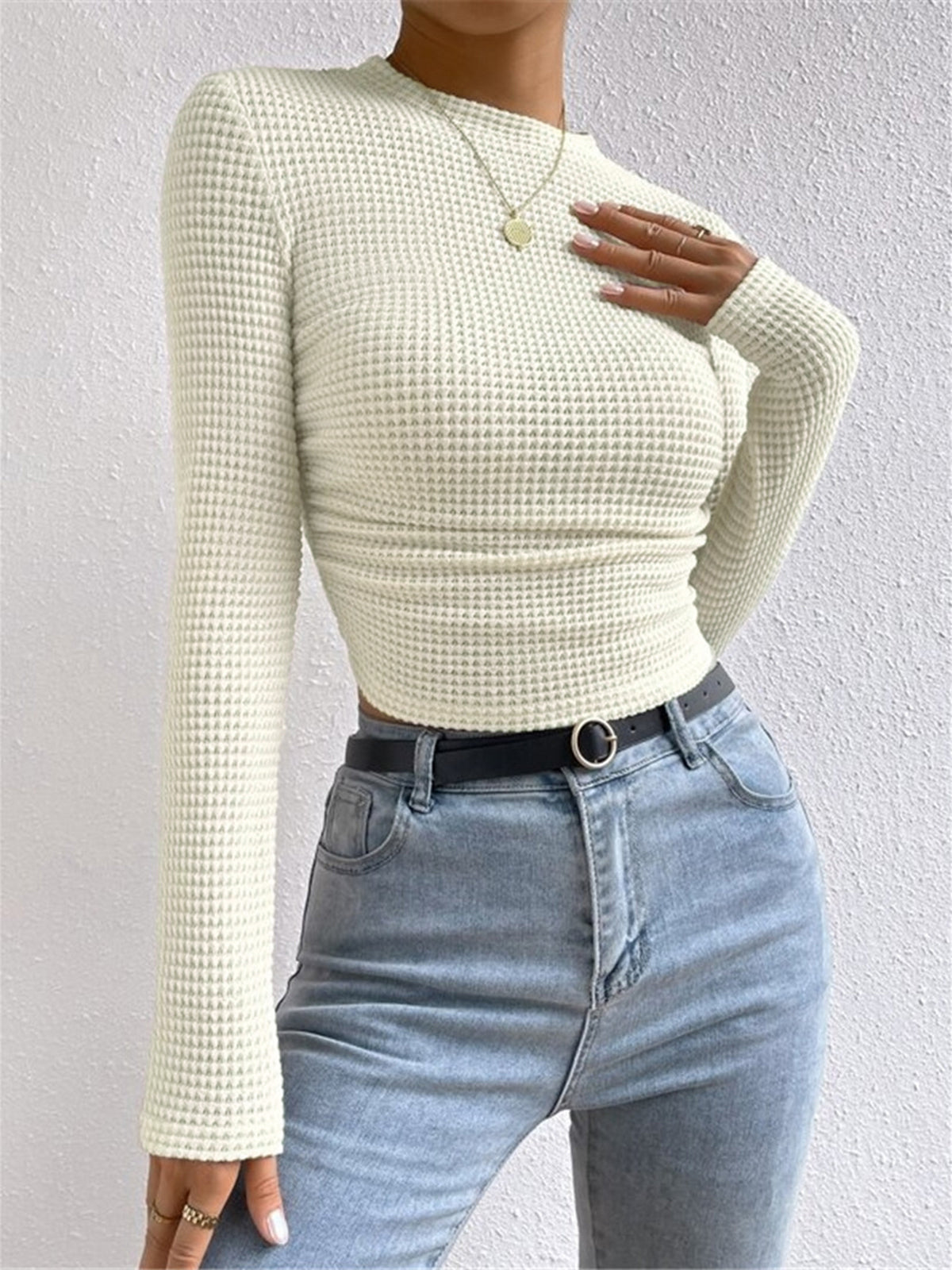 Light cream waffle-knit long-sleeve slim crop top with ruched waist and crew neck.