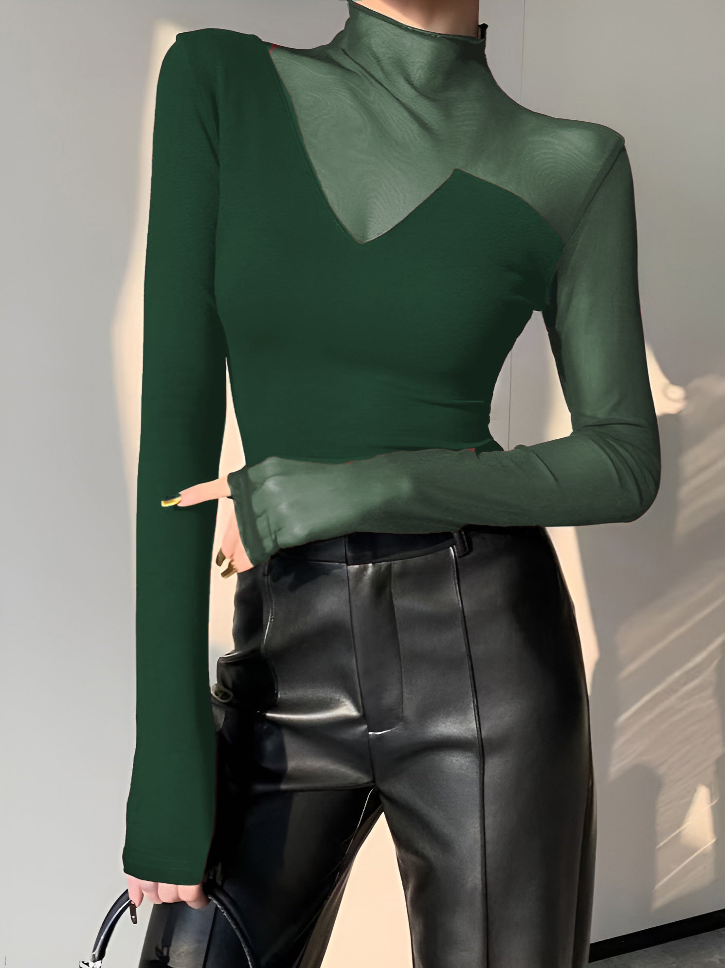 Green mesh long-sleeve top with mock neck and asymmetric sheer insert at bust
