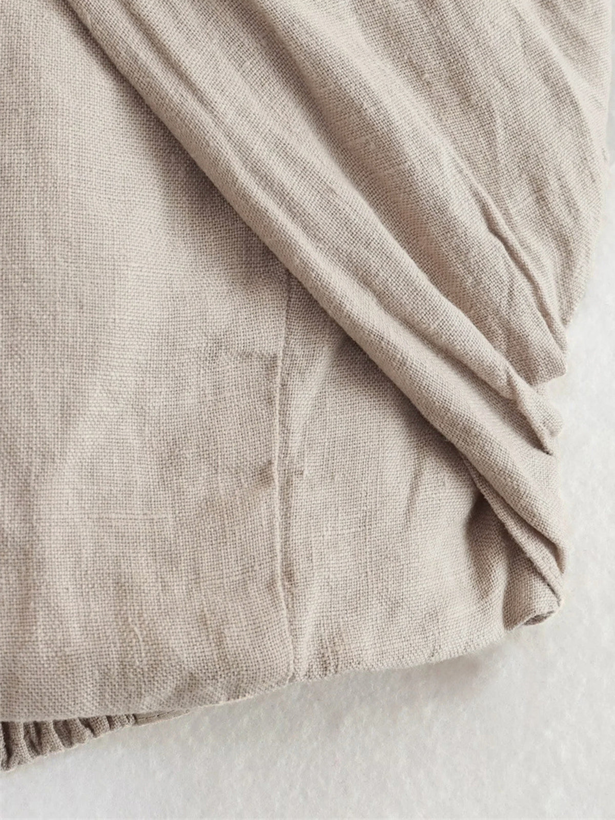 Beige cotton fabric swatch with fine woven texture
