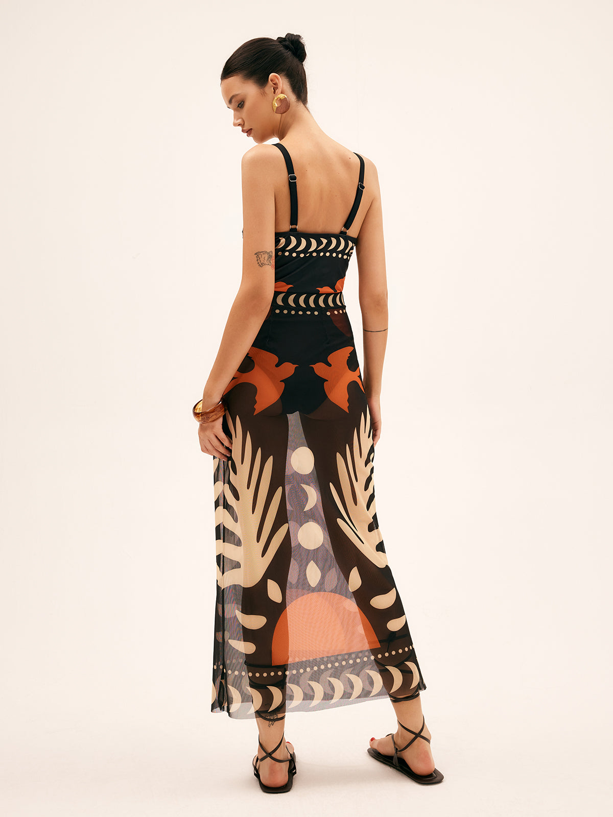 Back view sheer chiffon maxi skirt with black, orange, and beige abstract tropical print