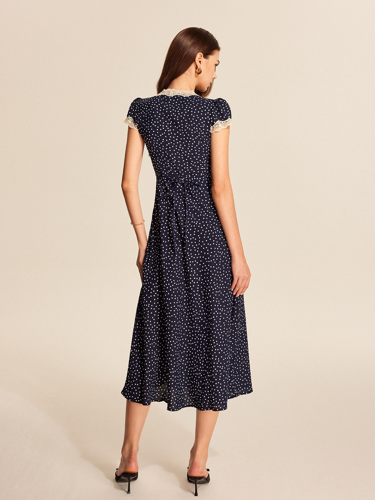 Navy satin polka-dot midi dress from back view with cap sleeves