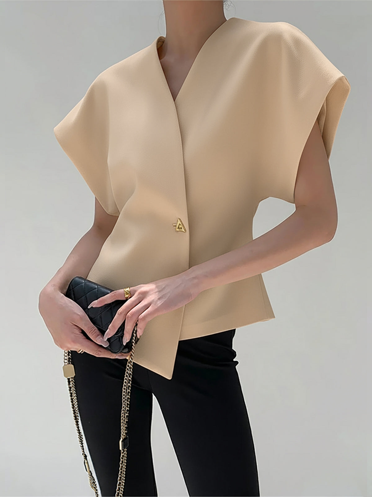 Cream crepe blouse with V-neck, cap sleeves, and an asymmetric gold button detail
