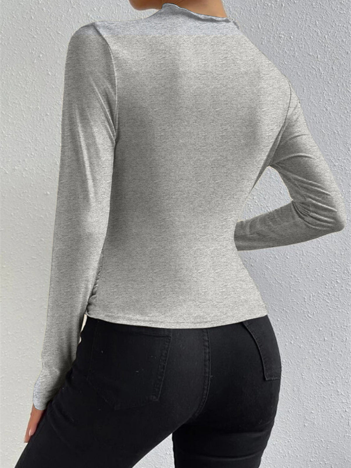 Light grey long-sleeve fitted top with crew neck and smooth back draping