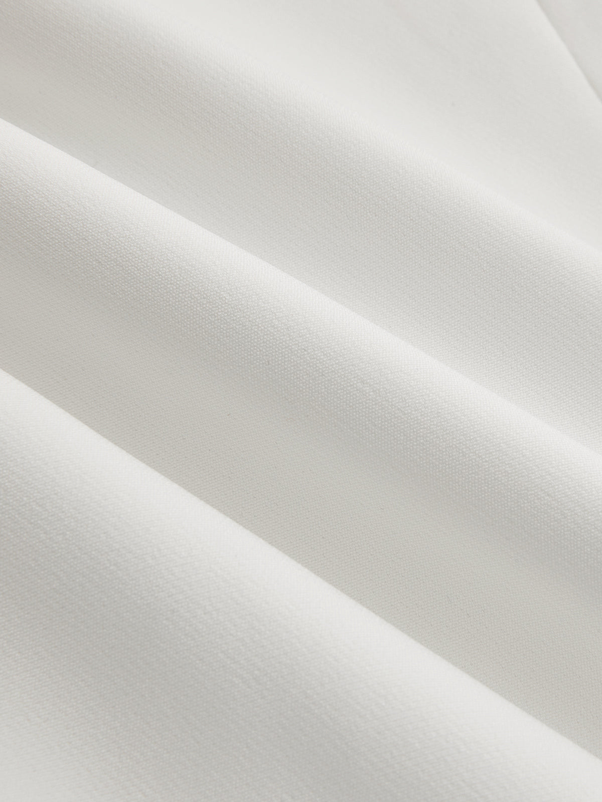 White crepe fabric close-up with fine texture and subtle weave