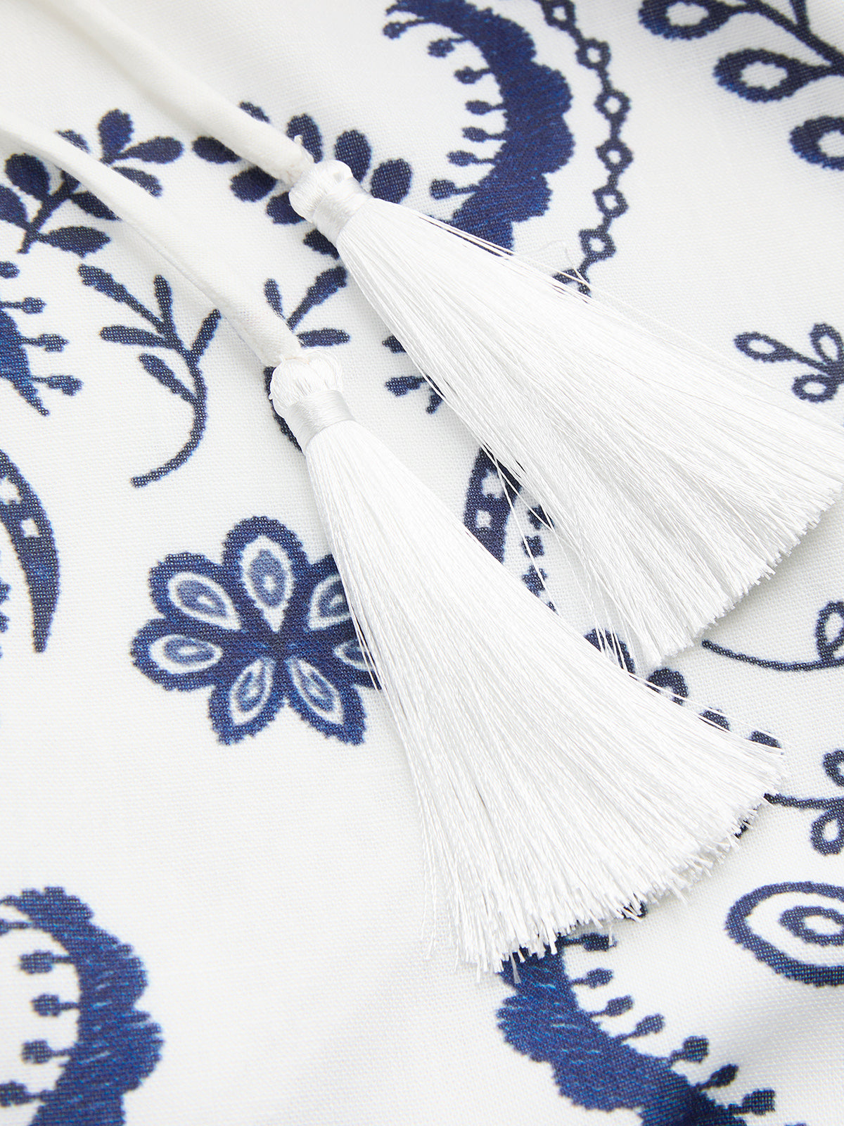White tassel tie detail on blue-and-white embroidered cami dress