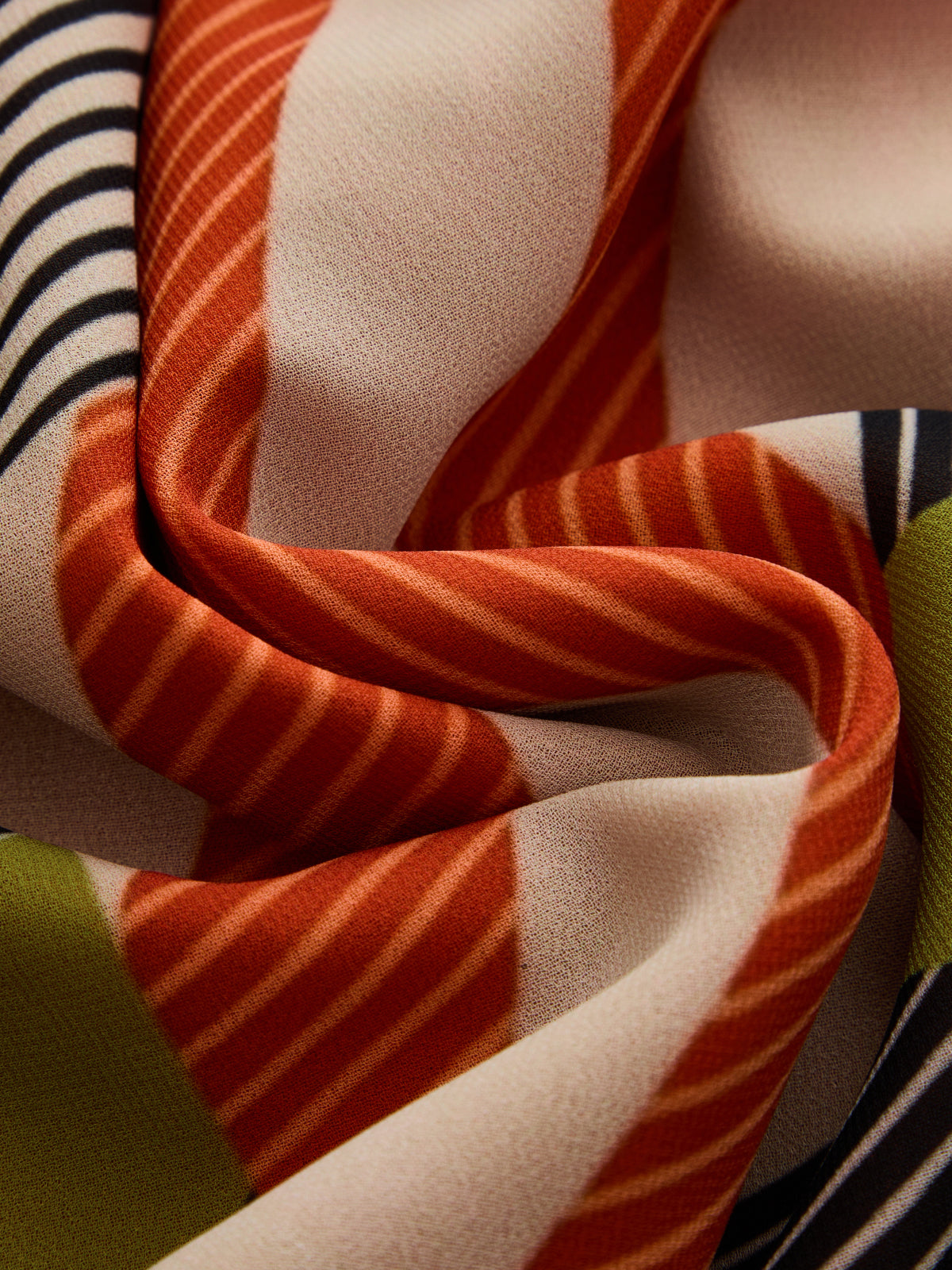 Multicolor striped fabric close-up with orange, olive, and navy folds