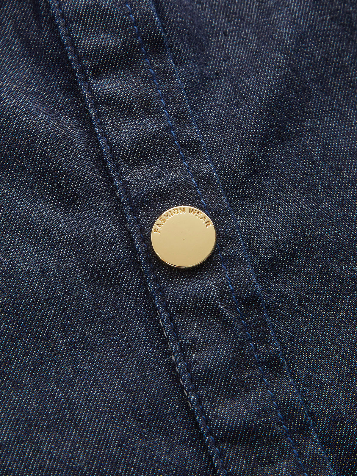 Navy denim dress close-up: gold button and stitched front placket detail