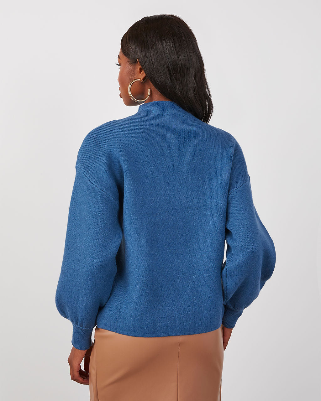 Blue mock neck sweater with long sleeves shown from the back; ribbed cuffs.