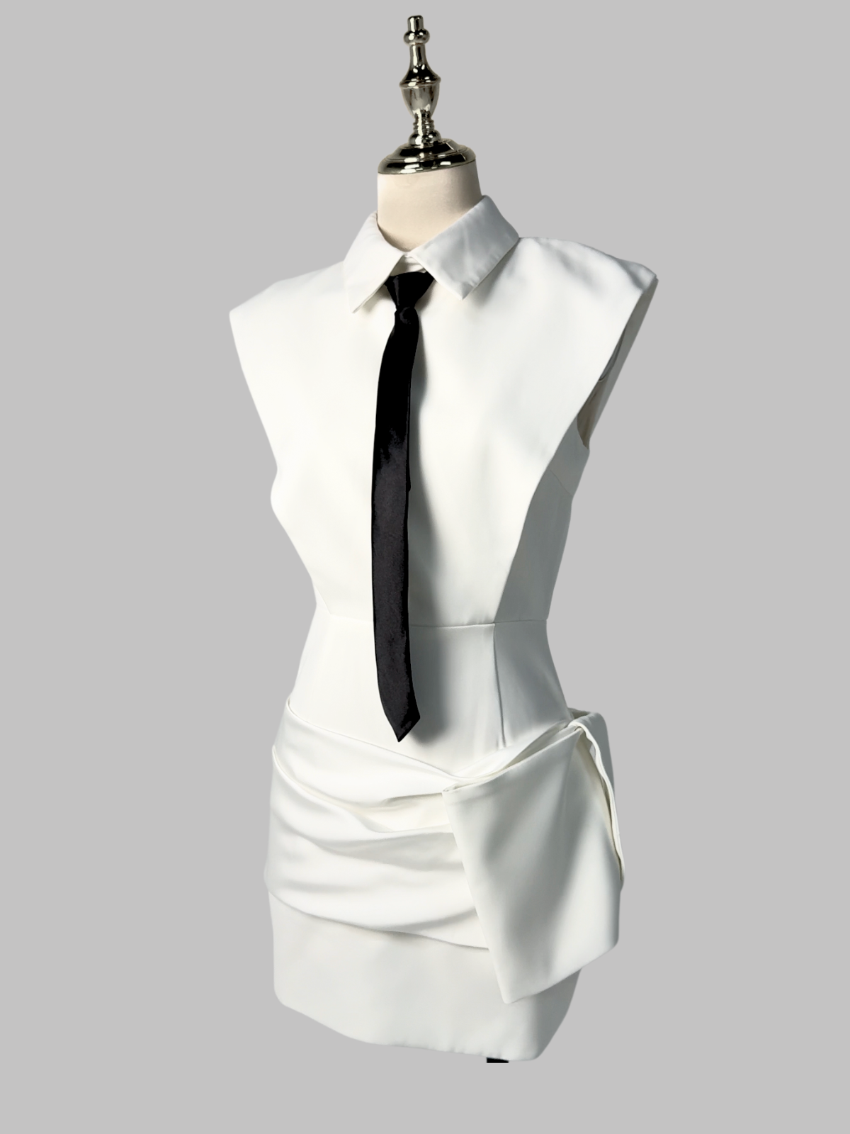 White sleeveless mini dress with folded collar, black necktie, layered front drape
