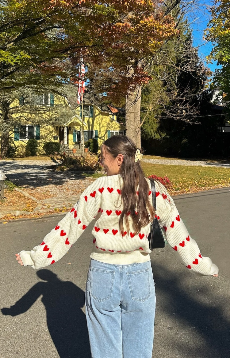 White heart-pattern knit jumper showing back, red stripe hearts and long sleeves