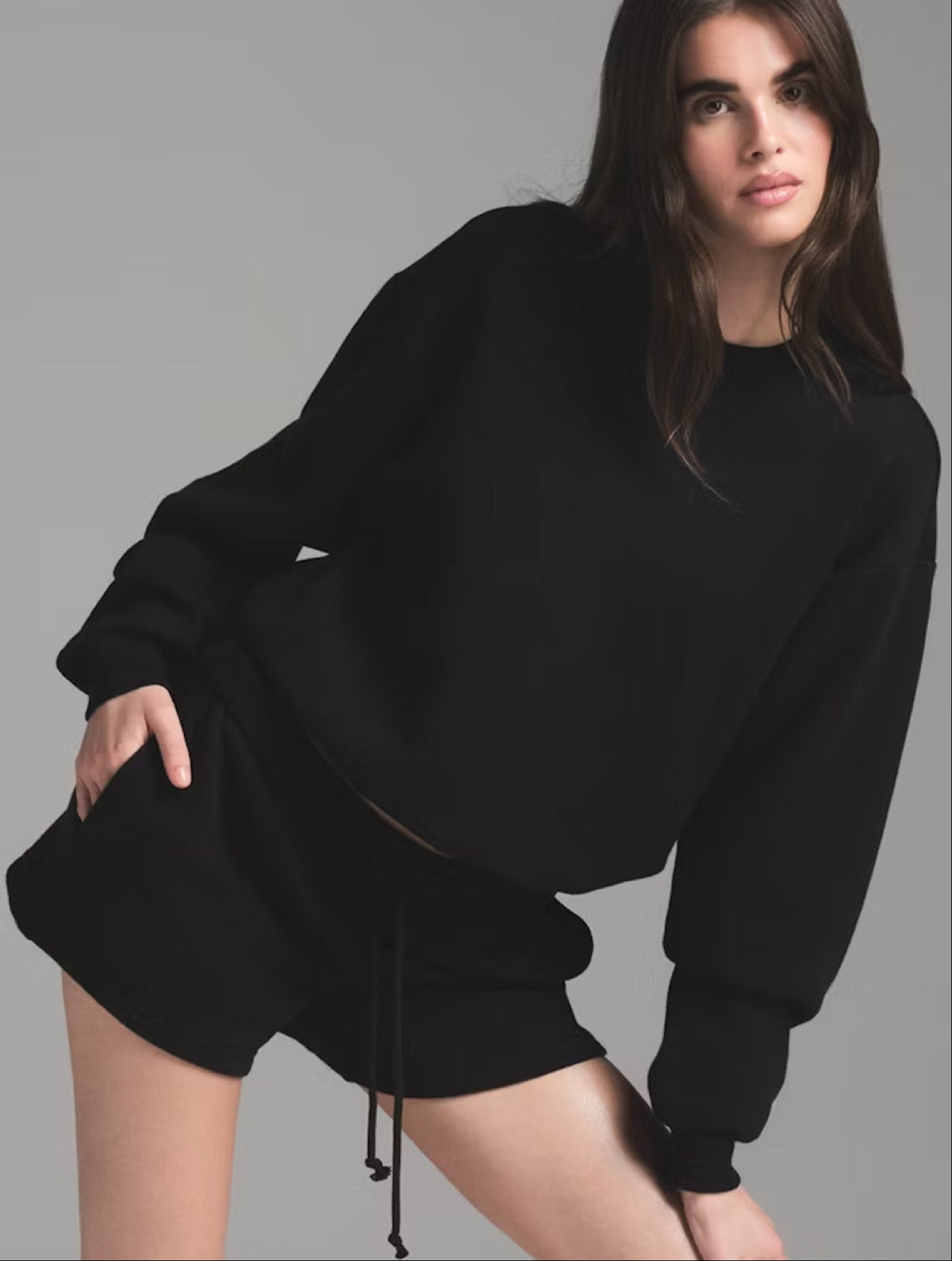 Women’s black sweatshirt and shorts set with round neck, long sleeves, and drawstring waist.