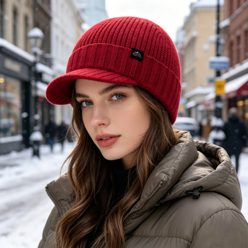 Deep red ribbed knit beanie with folded brim and small logo patch