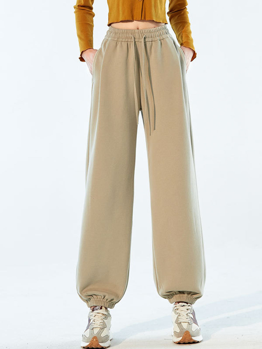 Beige high-waist sweatpants with elastic waist, drawstring, and tapered cuffed hem.