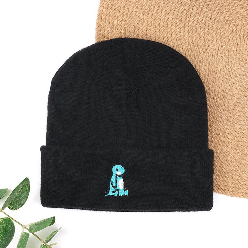 Black knit beanie with small blue embroidered character