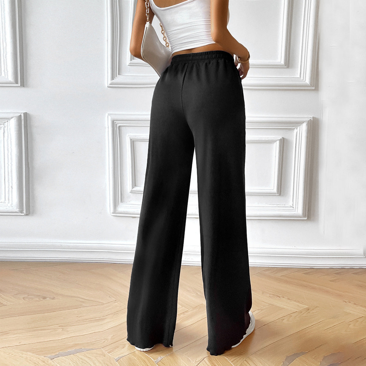 Black wide-leg drawstring pants with elastic waist and flowing straight legs