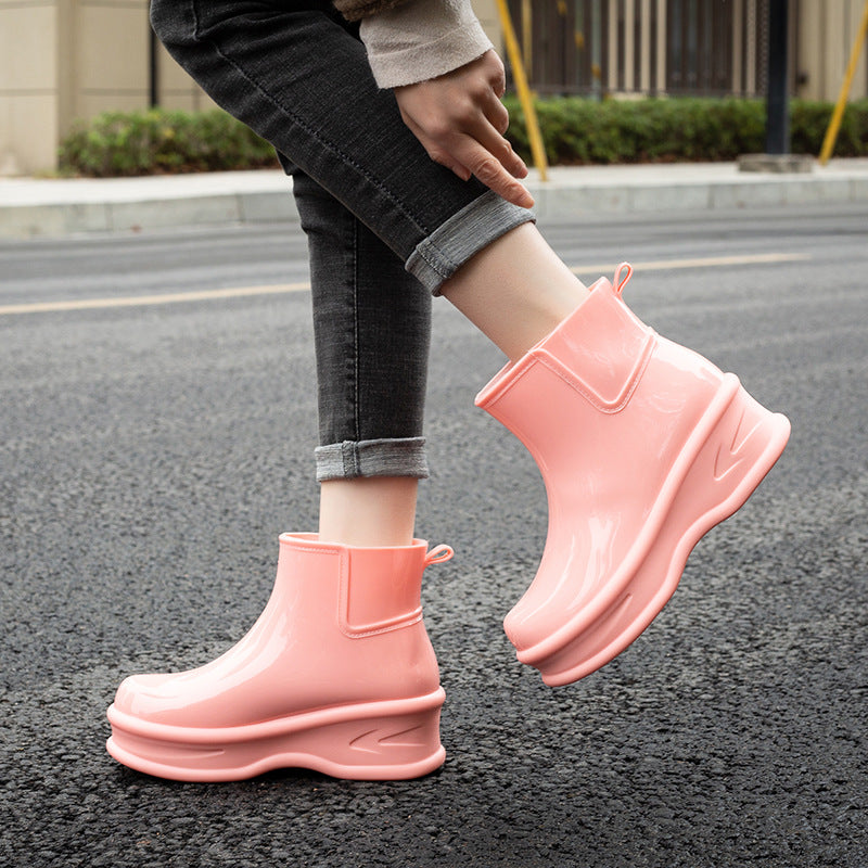Coral pink glossy mid-calf rain boots with platform sole and side pull-tab
