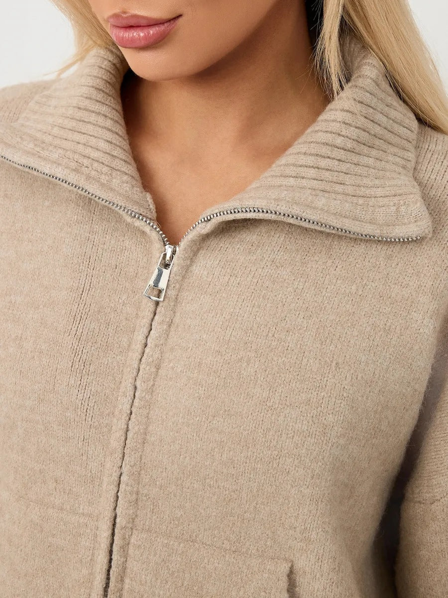Women’s beige knit zip-up sweater with stand-up collar and metal zipper pull