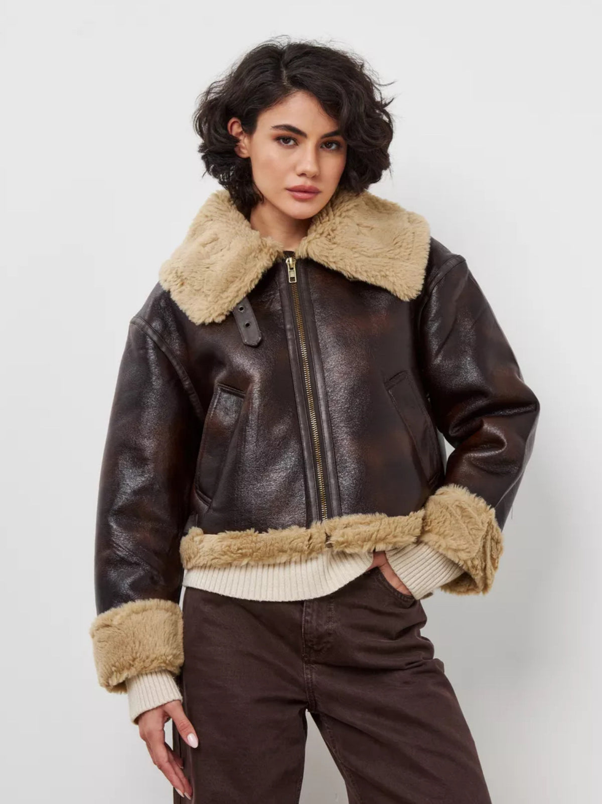 Women's brown leather jacket with tan shearling-lined hood collar, zip closure, cuffs