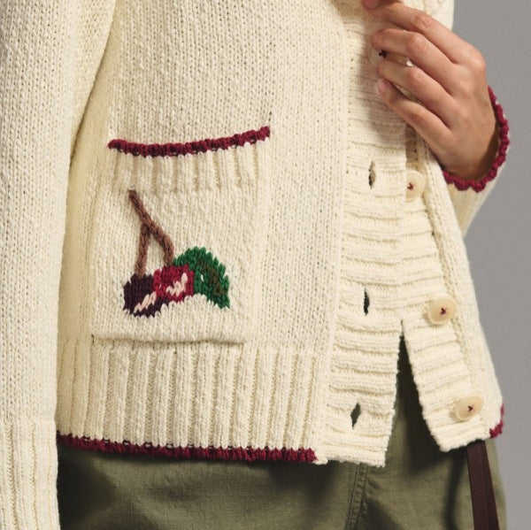 Beige knit cardigan detail: embroidered pocket and button placket with ribbed trim