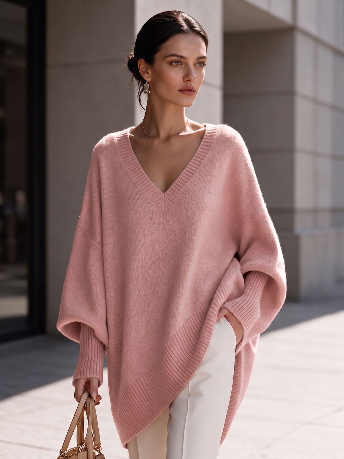 Women's pink V-neck knit pullover with batwing sleeves and asymmetric hem