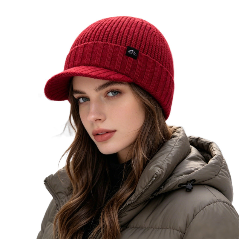 Deep red ribbed knit beanie with folded brim and small logo patch