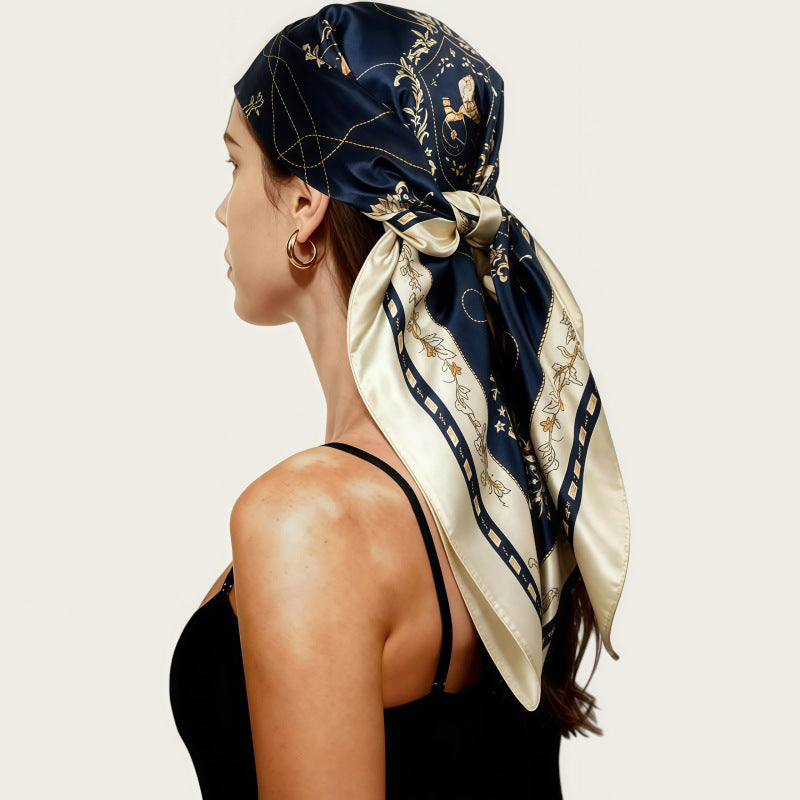 Navy silk square scarf with cream chain-and-motif print, tied side bow
