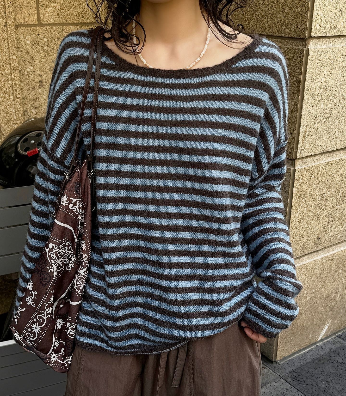 Blue-and-gray striped wool sweater with relaxed loose fit and round neckline.