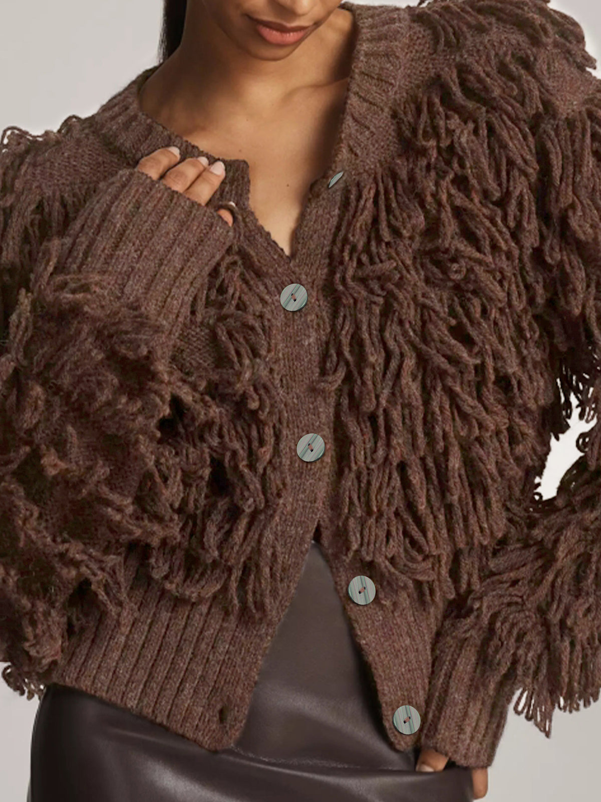 Brown knitted jacket with fringe tassels, ribbed cuffs, and button front