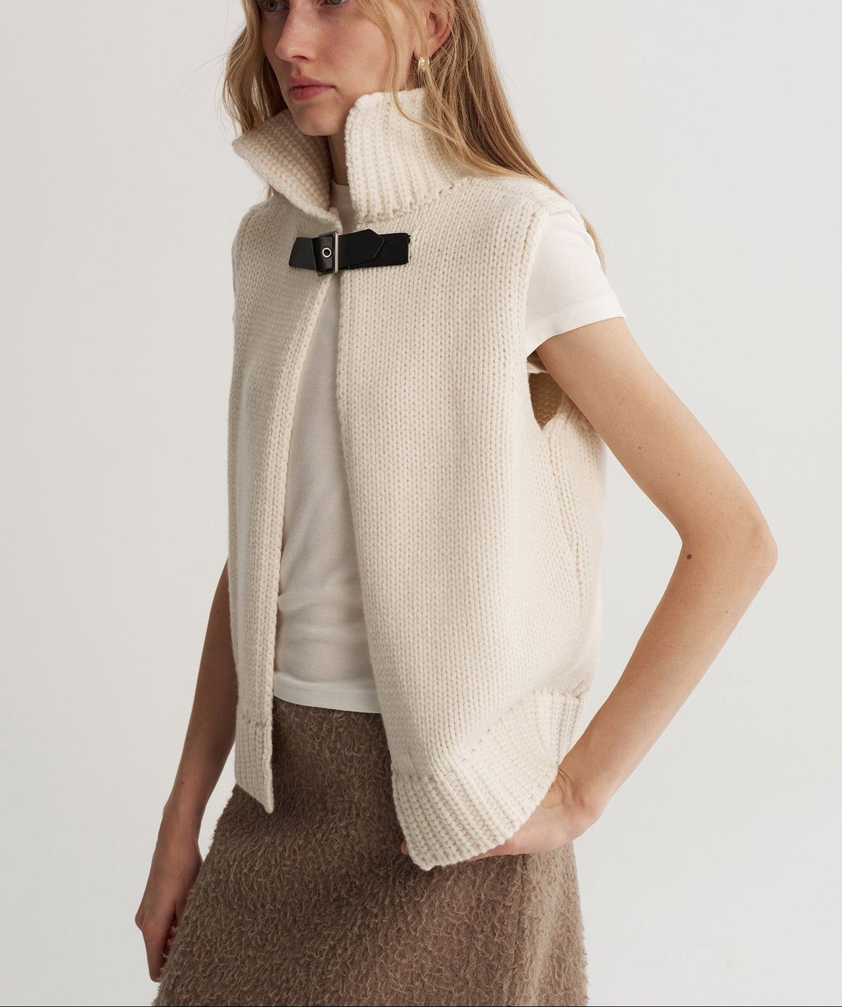 Cream reversible wool knit vest with stand-up collar and black snap belt closure