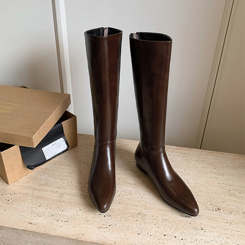 Pair of brown knee-high leather boots with pointed toe and hidden heel