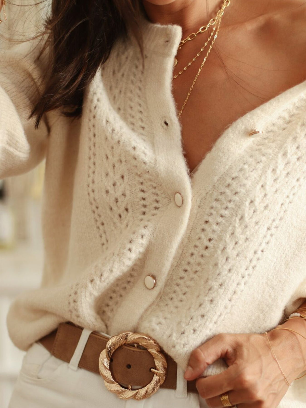 Cream cardigan close-up showing openwork knit and single-breasted buttons
