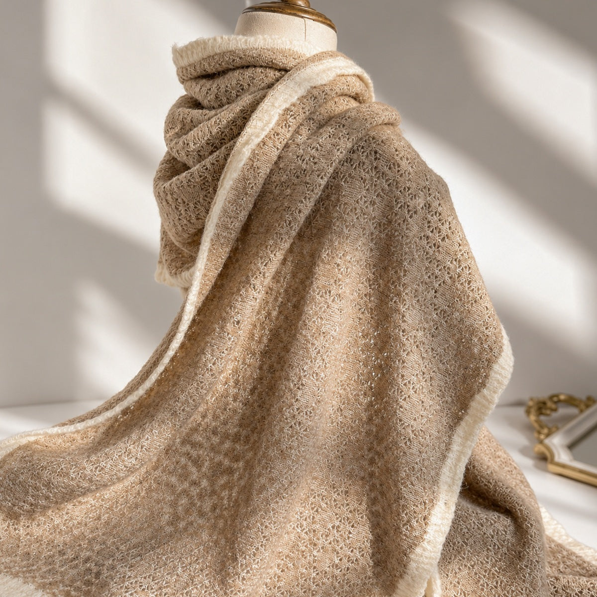 Light beige textured knit scarf with fringed ends, draped in soft folds.
