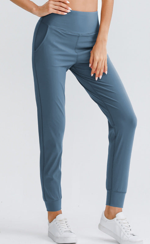 Women's blue yoga pants with elastic waistband and side pockets, ankle-length