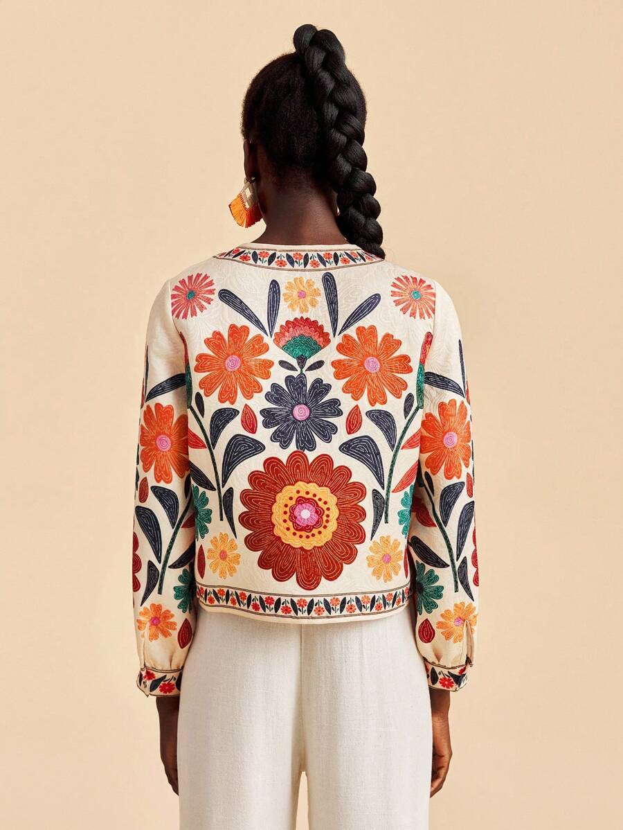 Women’s short floral jacket cardigan, back view, cream with large floral motif and trim
