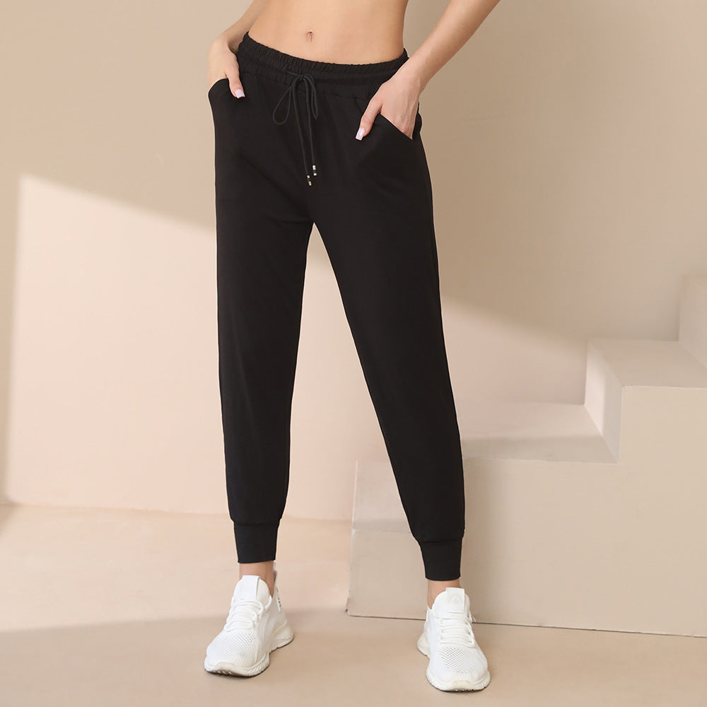 Black jogger pants with drawstring waist, ankle cuffs, and side pockets detail