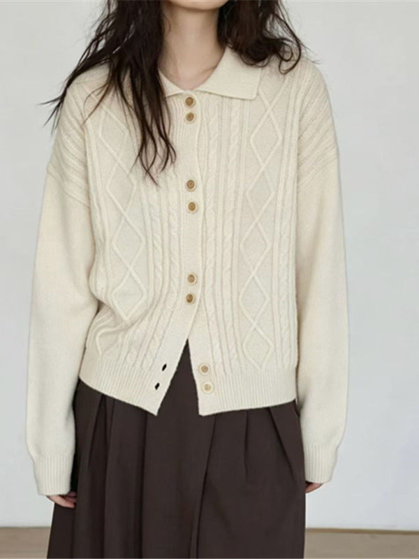Off-white cable-knit cardigan with pointed collar and button front, shown from the waist up