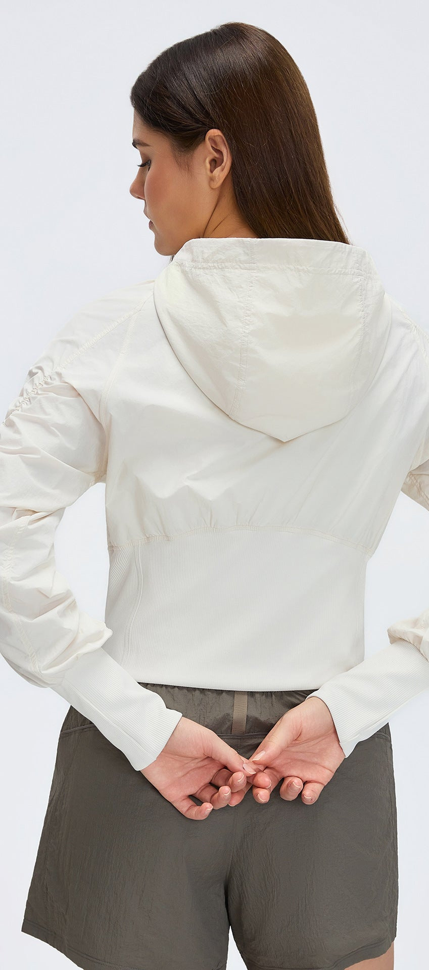 White cropped hooded zip-up windbreaker jacket, back view with ribbed waist band