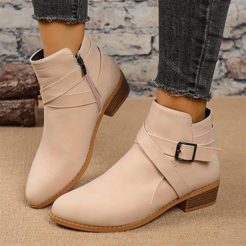 Light beige Chelsea ankle boots with side zipper, buckle strap, and block heel.