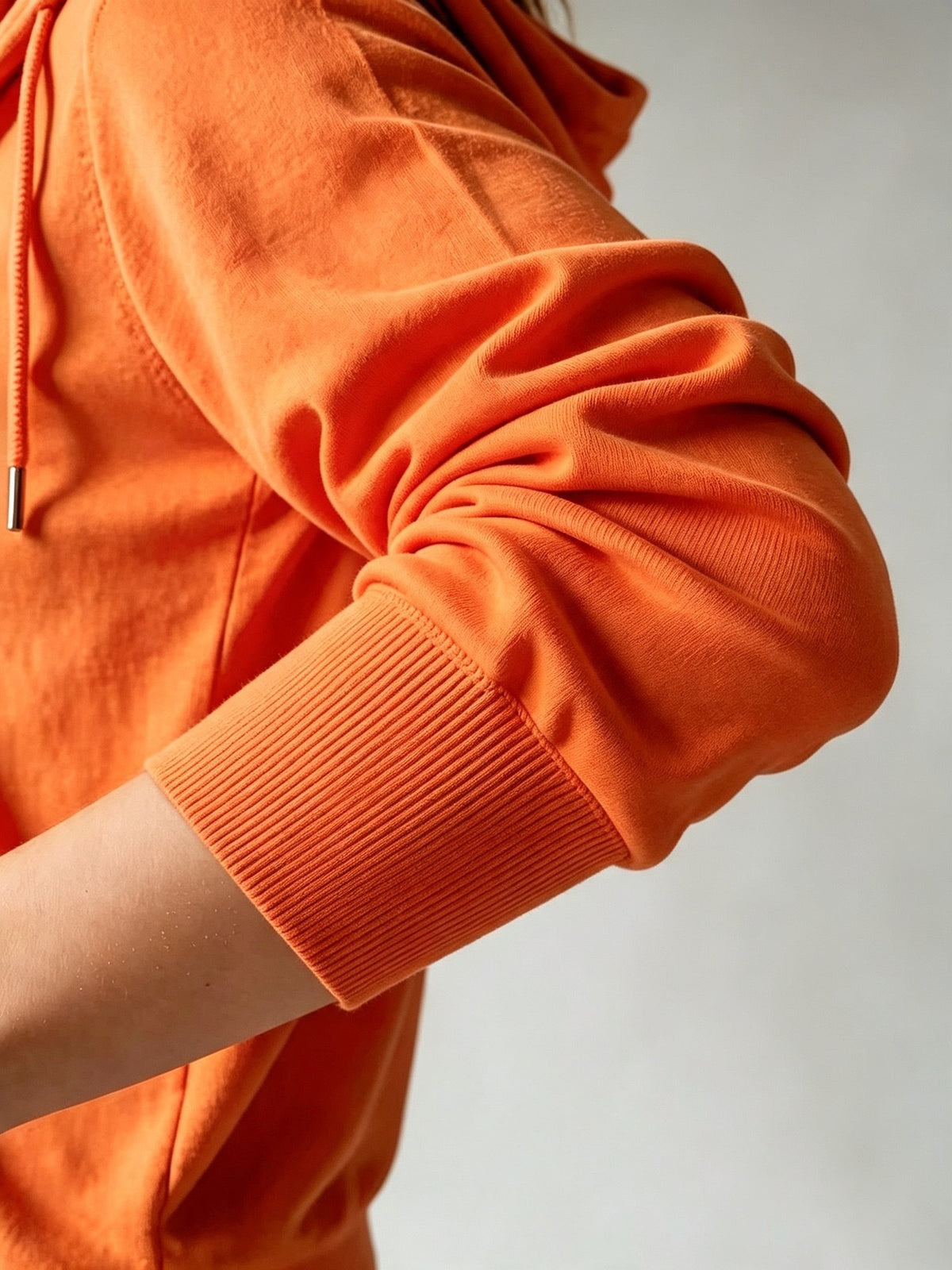 Women's orange knit sleeve detail with ribbed cuff and zip-up edge
