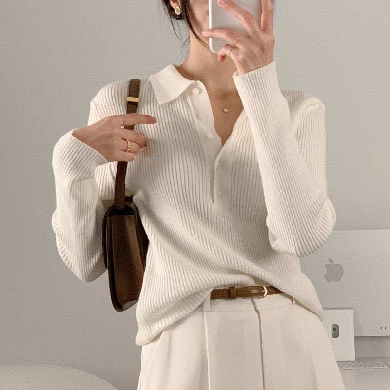 White ribbed knit polo collar long-sleeve top with button placket, fitted through arms.