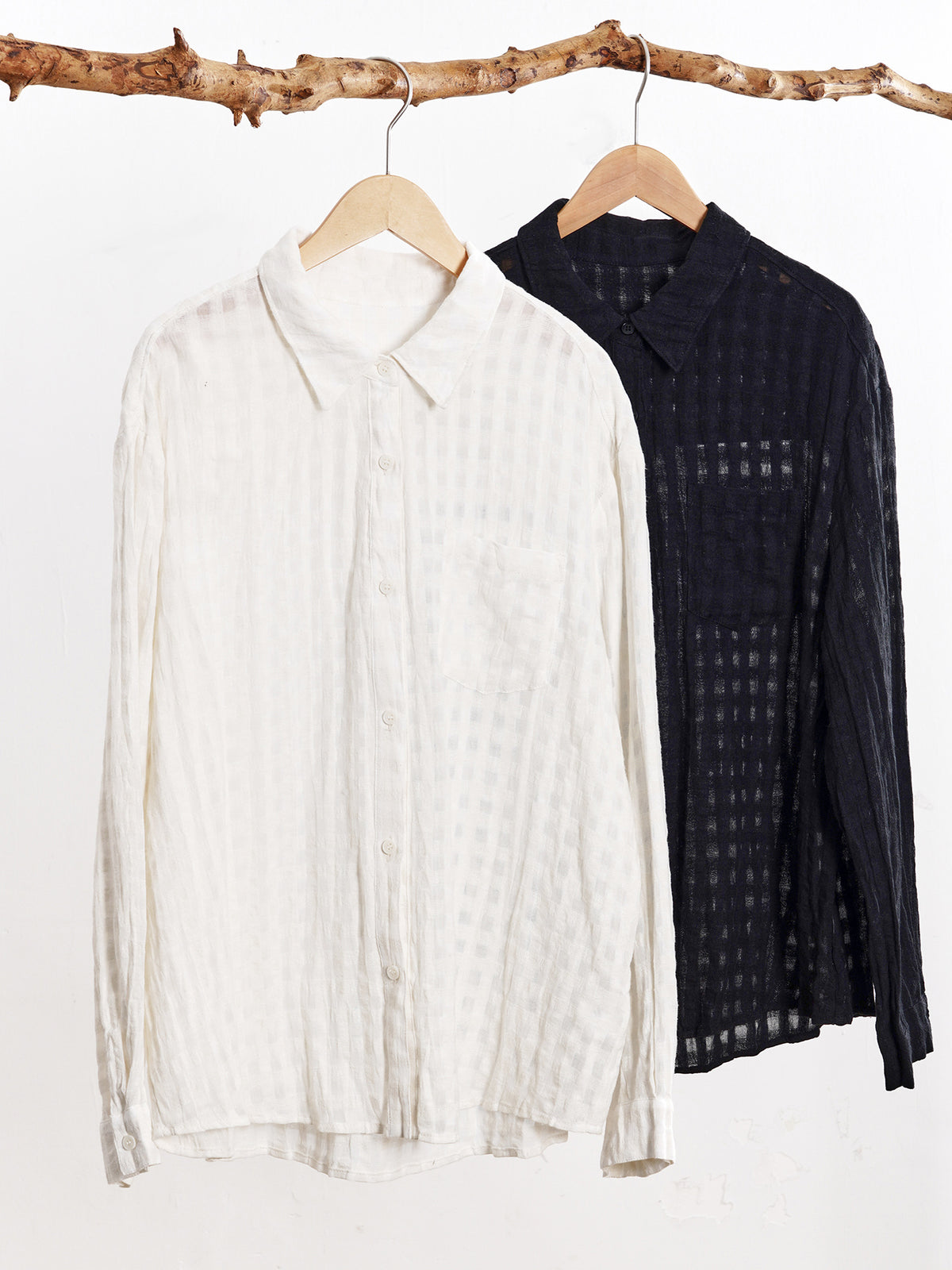 Hanging collared plaid shirts: off-white and black button-front long-sleeve styles