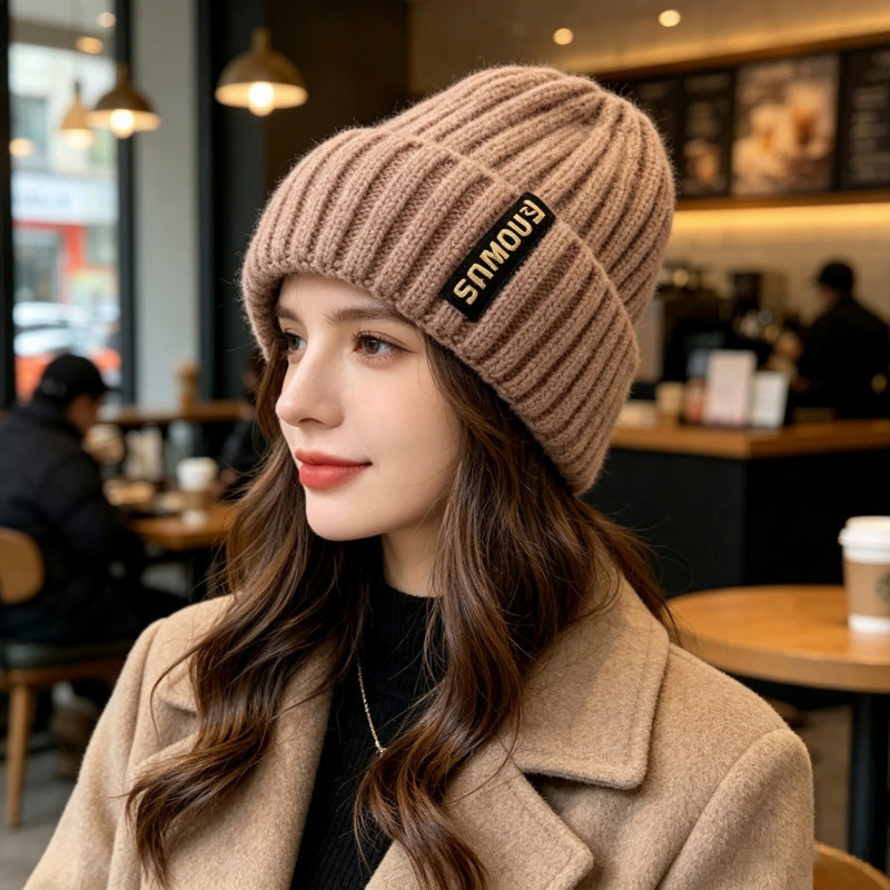 Taupe ribbed knit beanie with folded brim and black logo patch