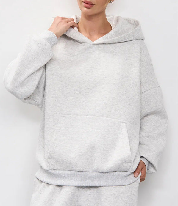 Light gray women’s hooded sweatshirt with front kangaroo pocket and long sleeves