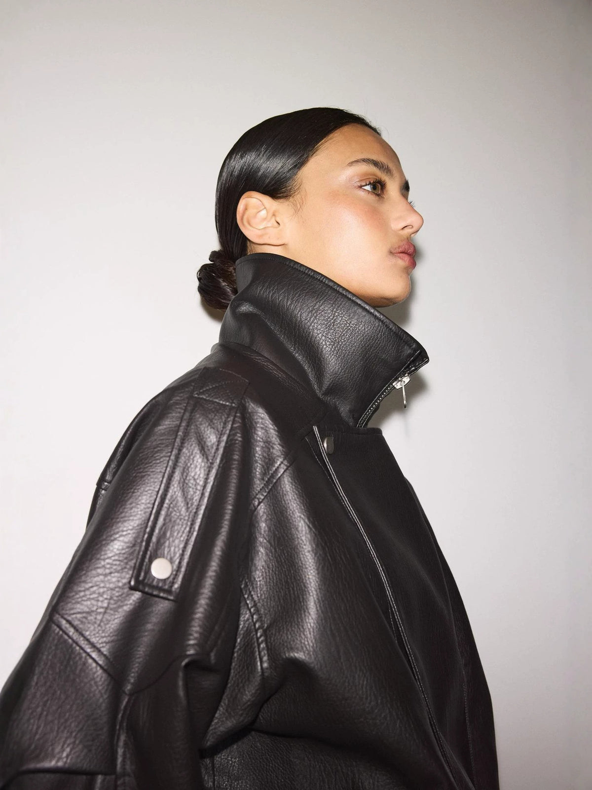 Black leather biker jacket, stand collar, snapped shoulder epaulette, side zip and pockets
