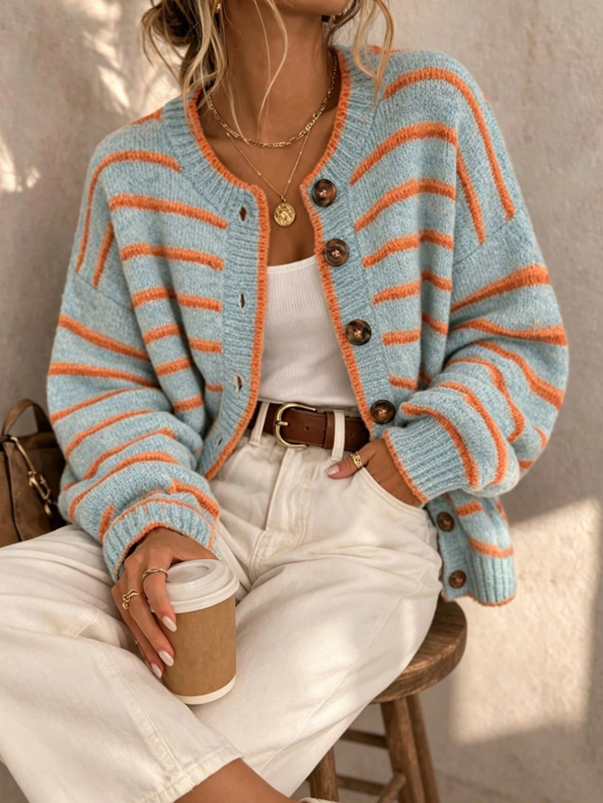 Light blue striped knit cardigan with orange stripes, button front and ribbed cuffs